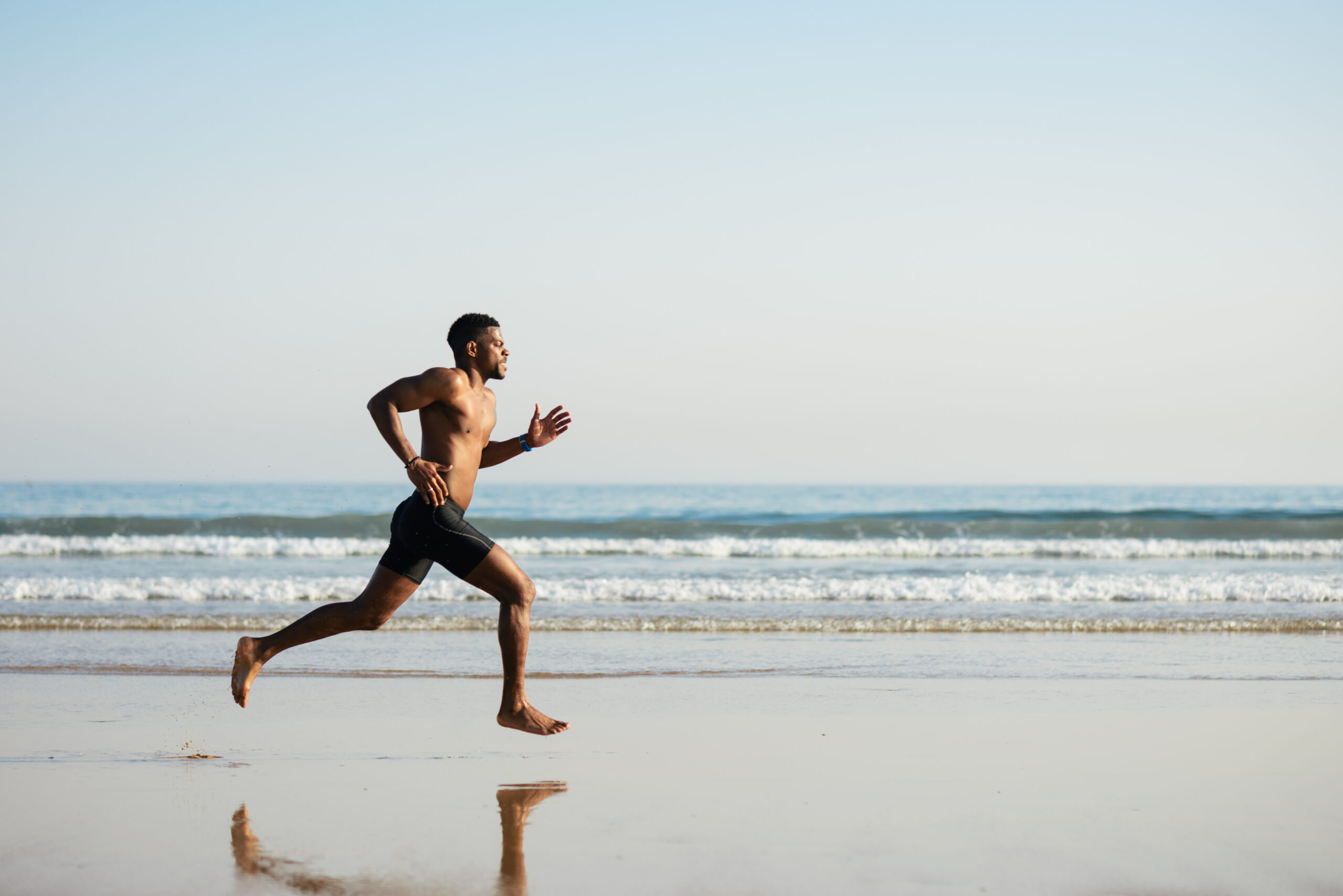 Man running barefoot on the beach