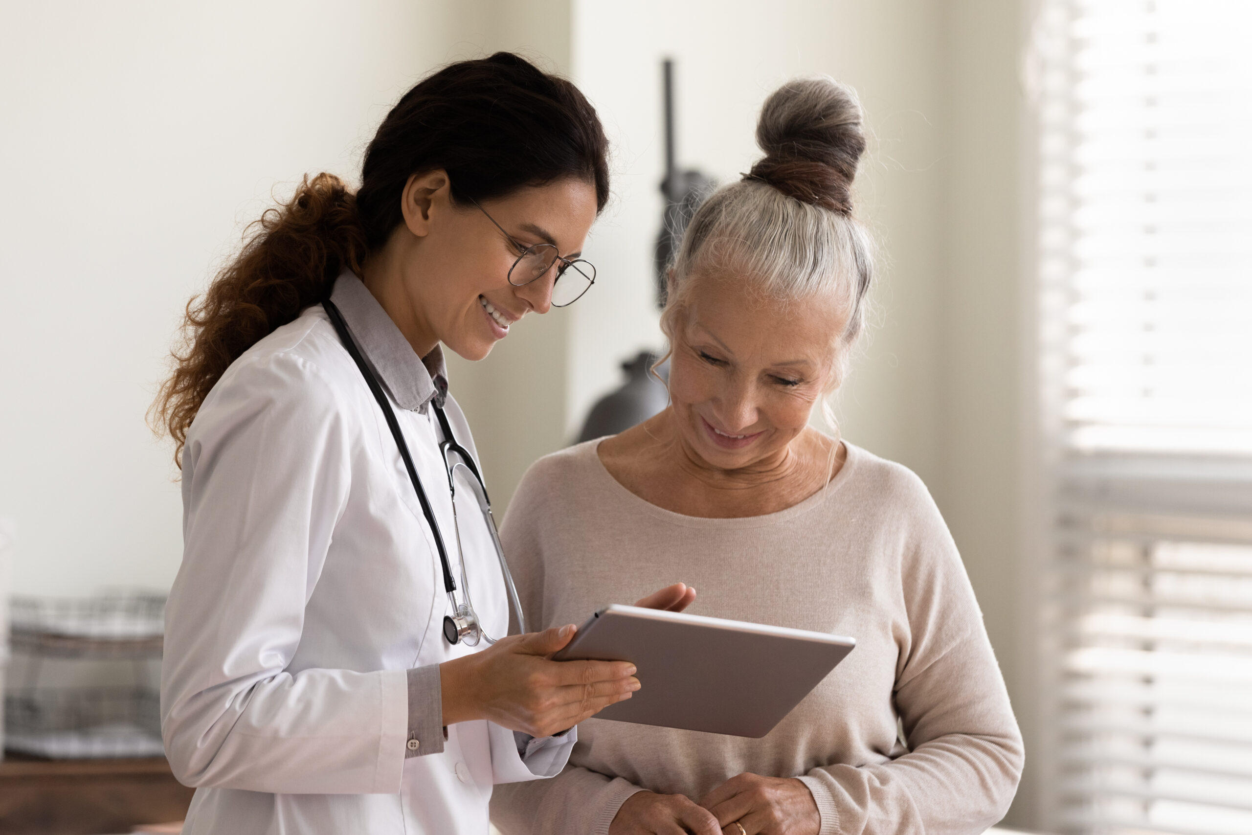 Happy female doctor and senior patient look at a chart