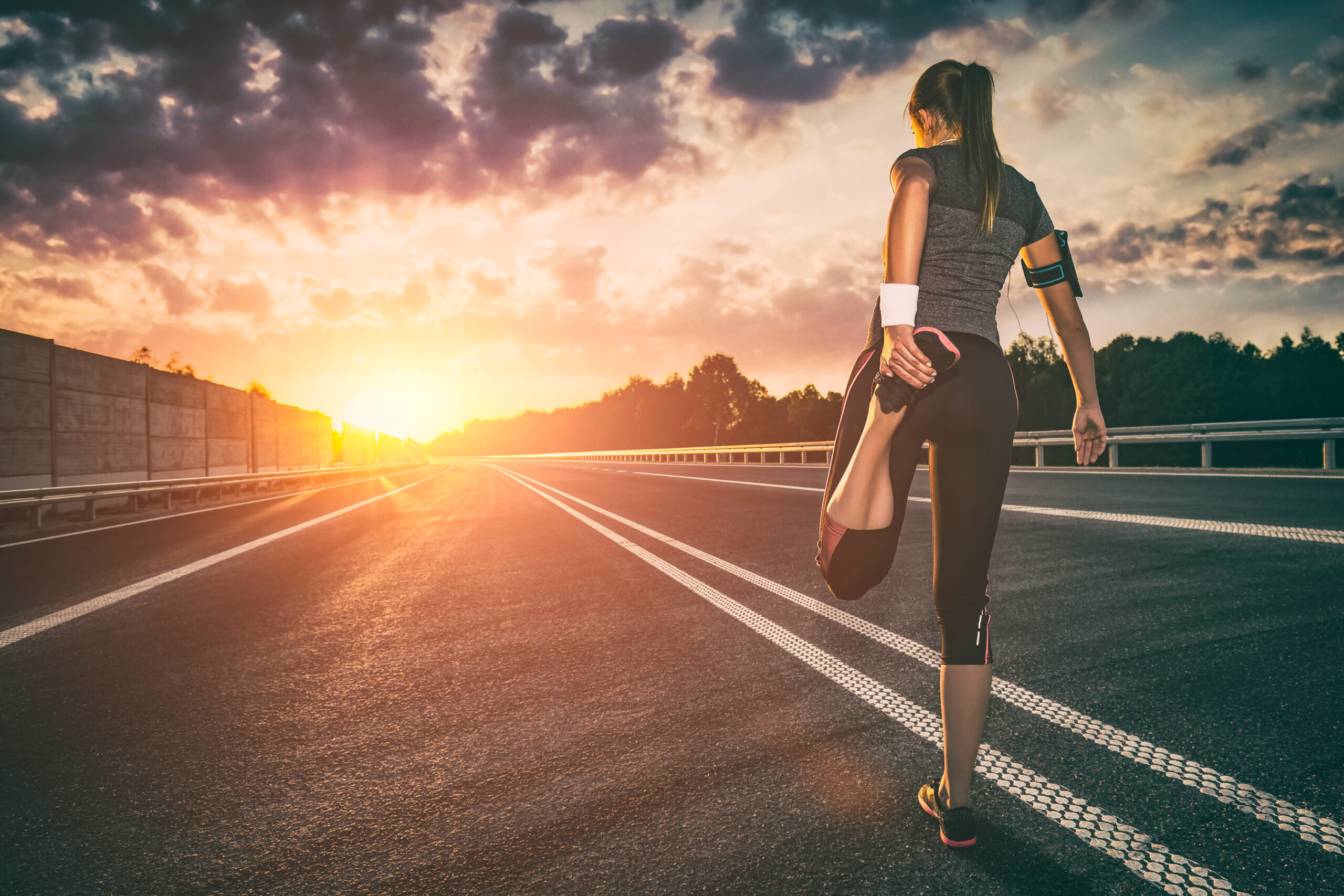 Runner stretching at sunset