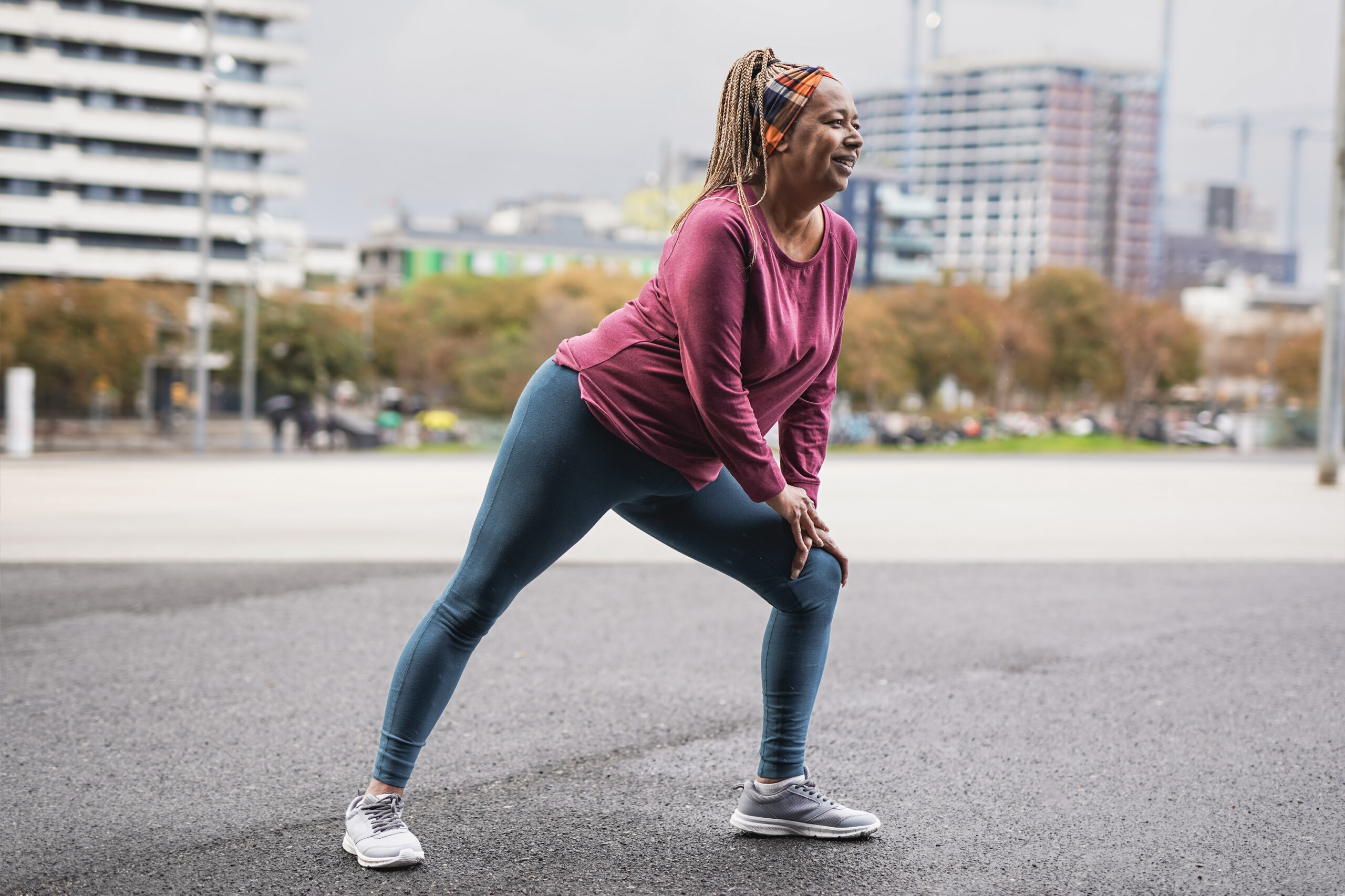 Fit senior woman stretching in the city