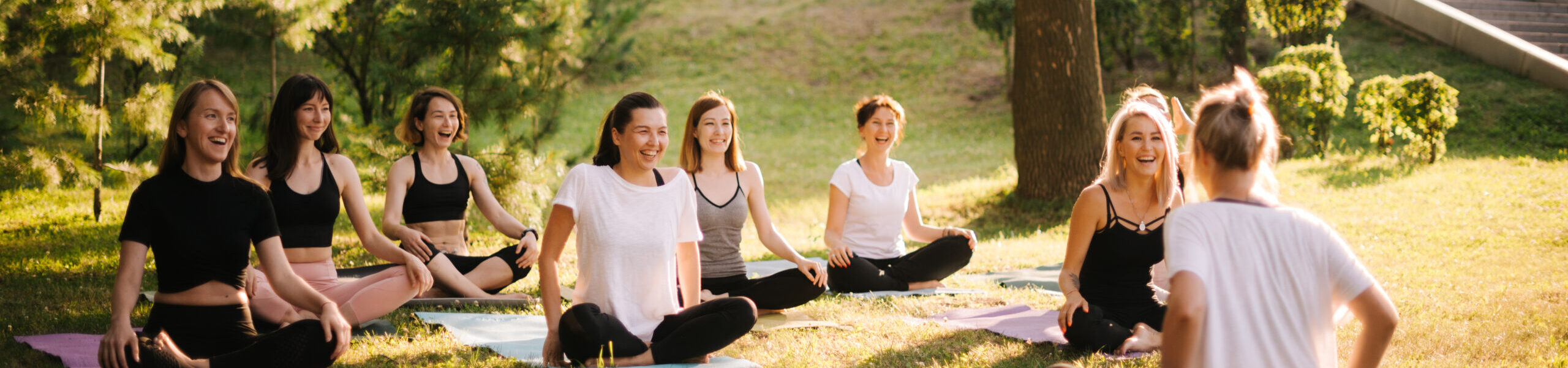 Group of smiling women prepare to meditate